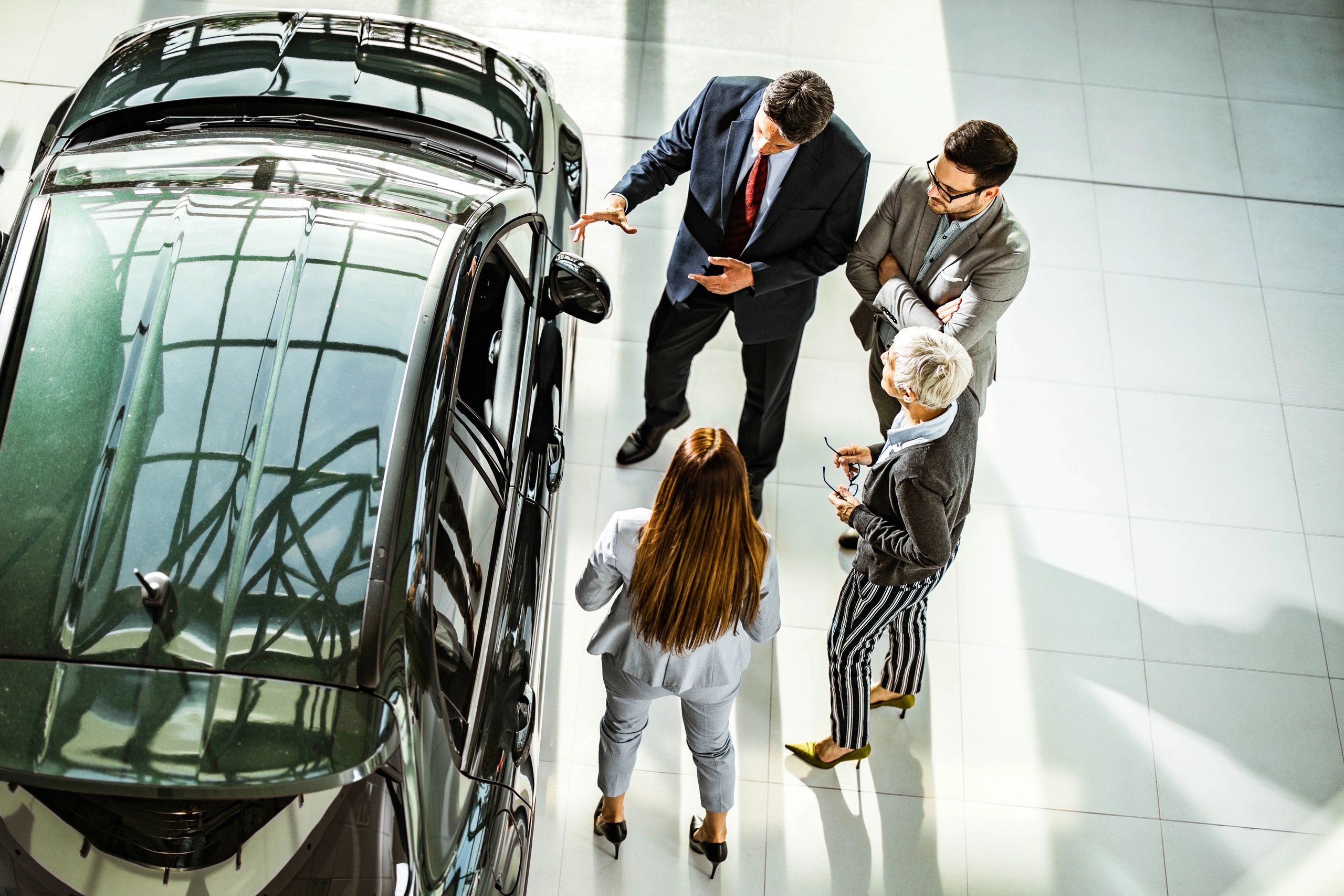 People discussing a vehicle in a car showroom