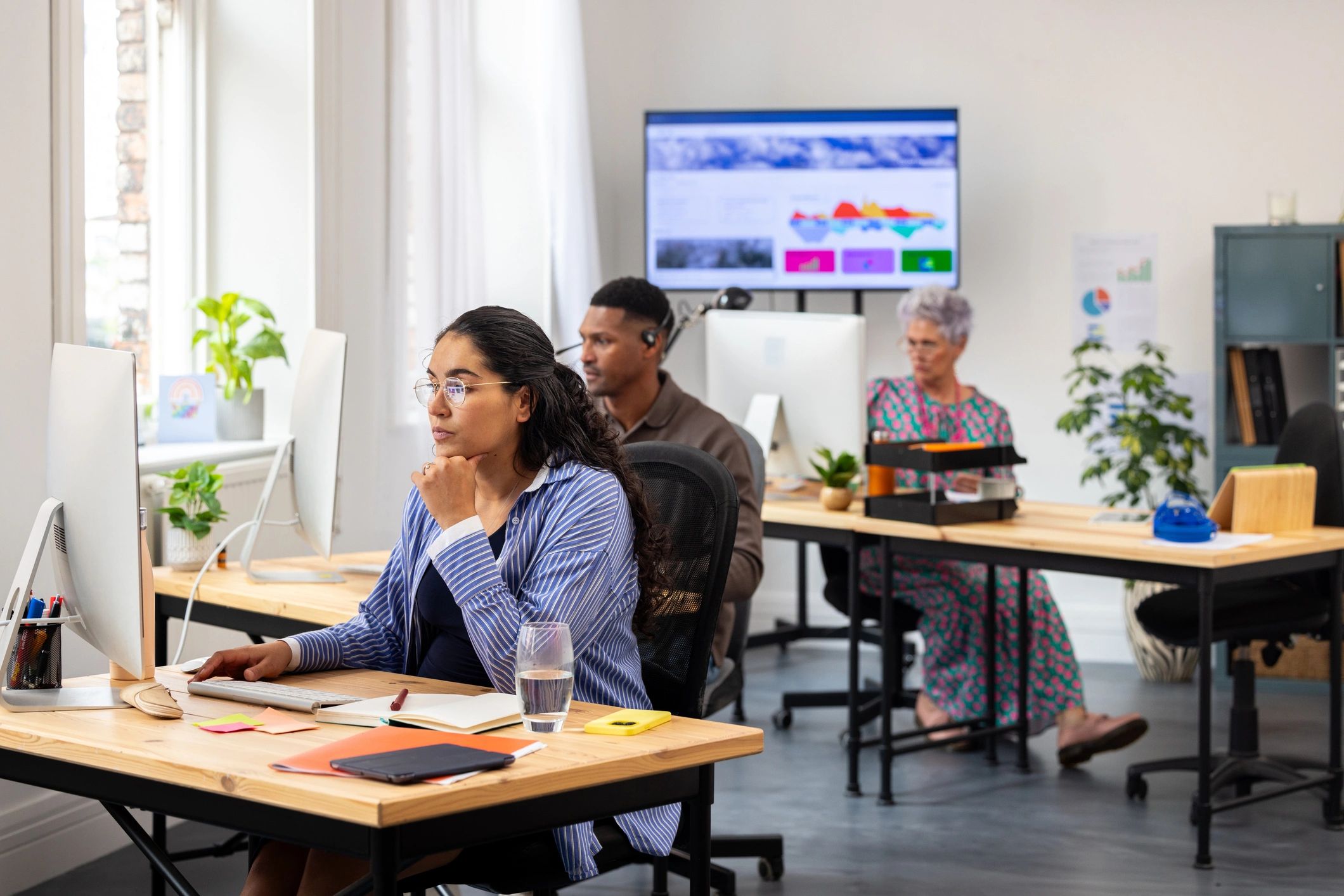 Modern newsroom-style office with people working