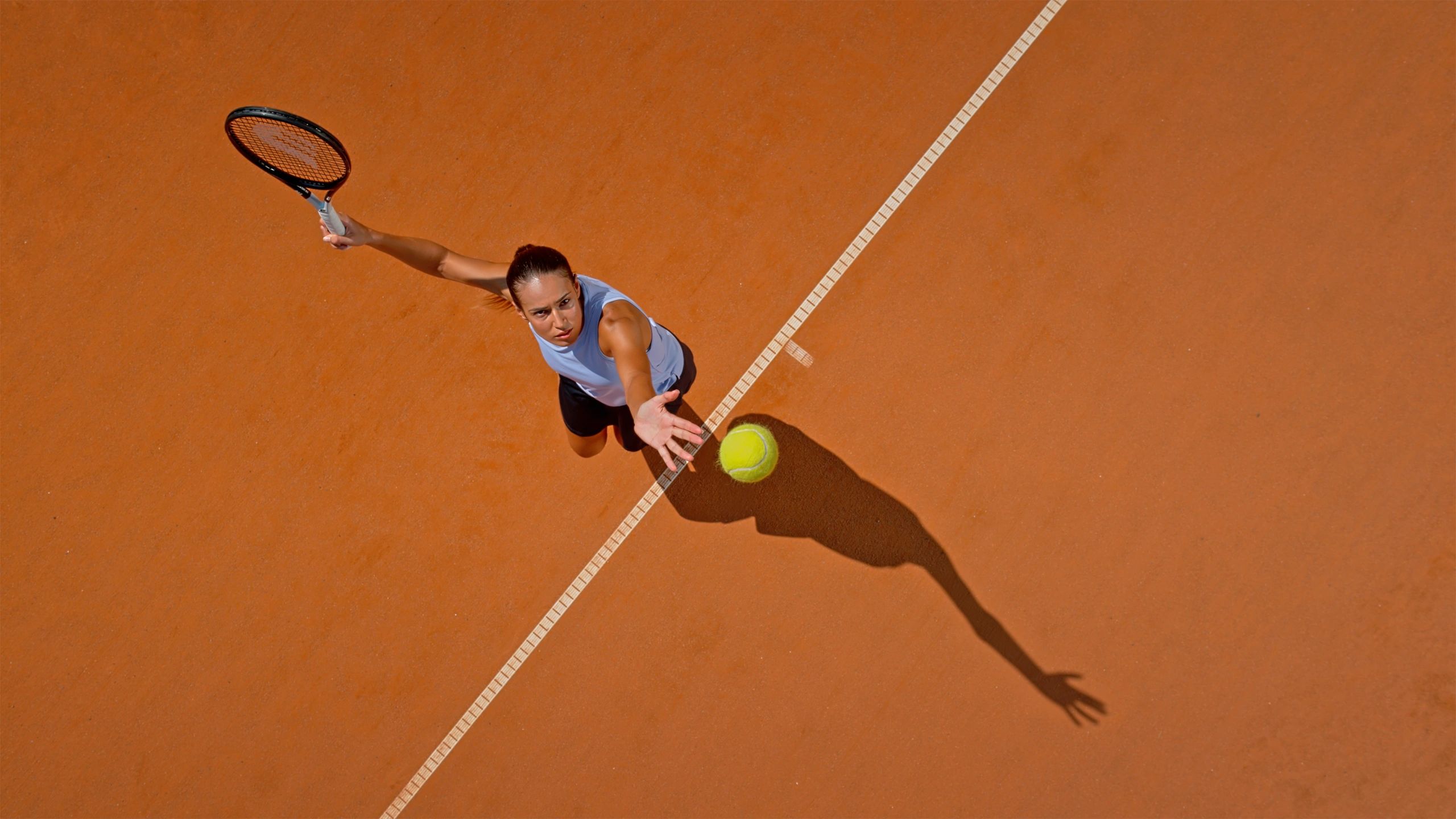 Tennis player serving on a clay court