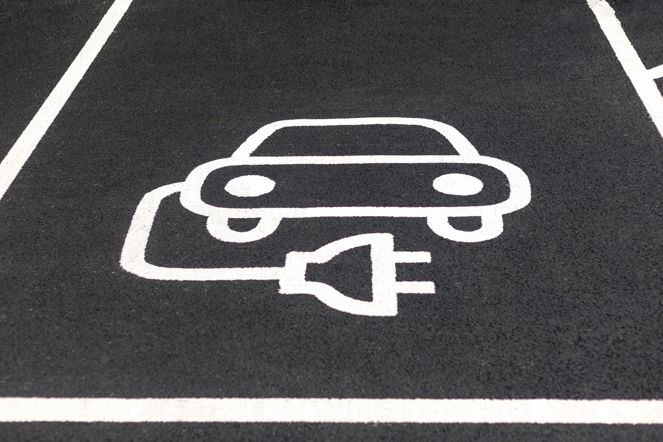 Electric vehicle charging symbol painted on pavement